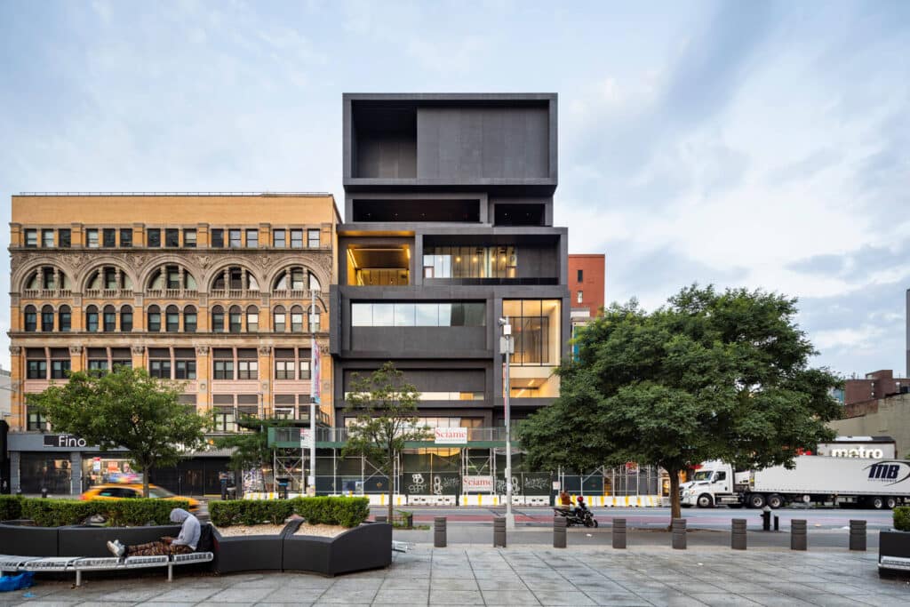 Alt (English): The fa&ccedil;ade of the Studio Museum in Harlem by Adjaye, where stacked vertical volumes and glazed surfaces engage with the pulse of 125th Street.