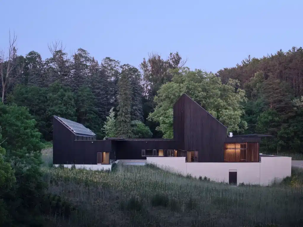 Exterior wooden pathways connect courtyards, flowing seamlessly with surrounding forests