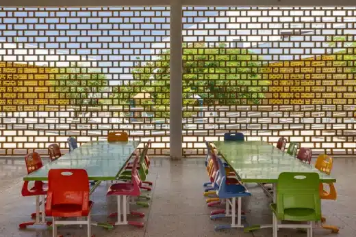 قاعة طعام مفتوحة محاطة بجدار كامل من الكوبوغو يسمح بمرور الضوء والنسيم.