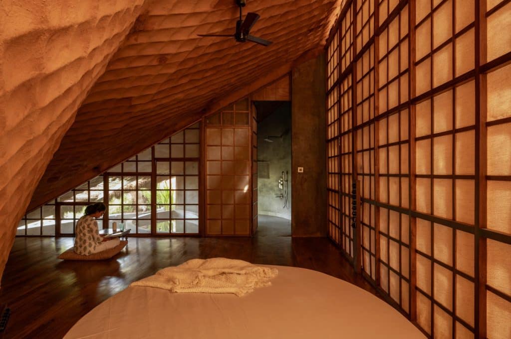 Interior of the bridge showing exposed mud walls and ceilings, semi-transparent screens, and hammock-like relaxation areas.