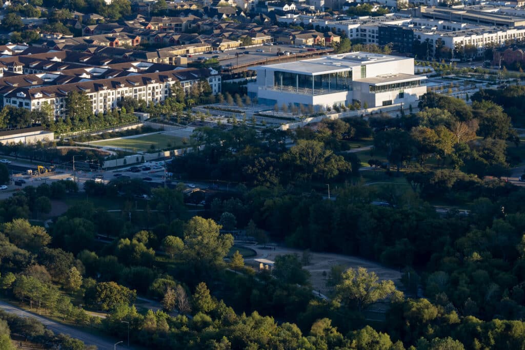 An aerial view showing the Ismaili Center as a serene oasis nestled between residential neighborhoods and lush greenery, embodying balance between modernity and nature.