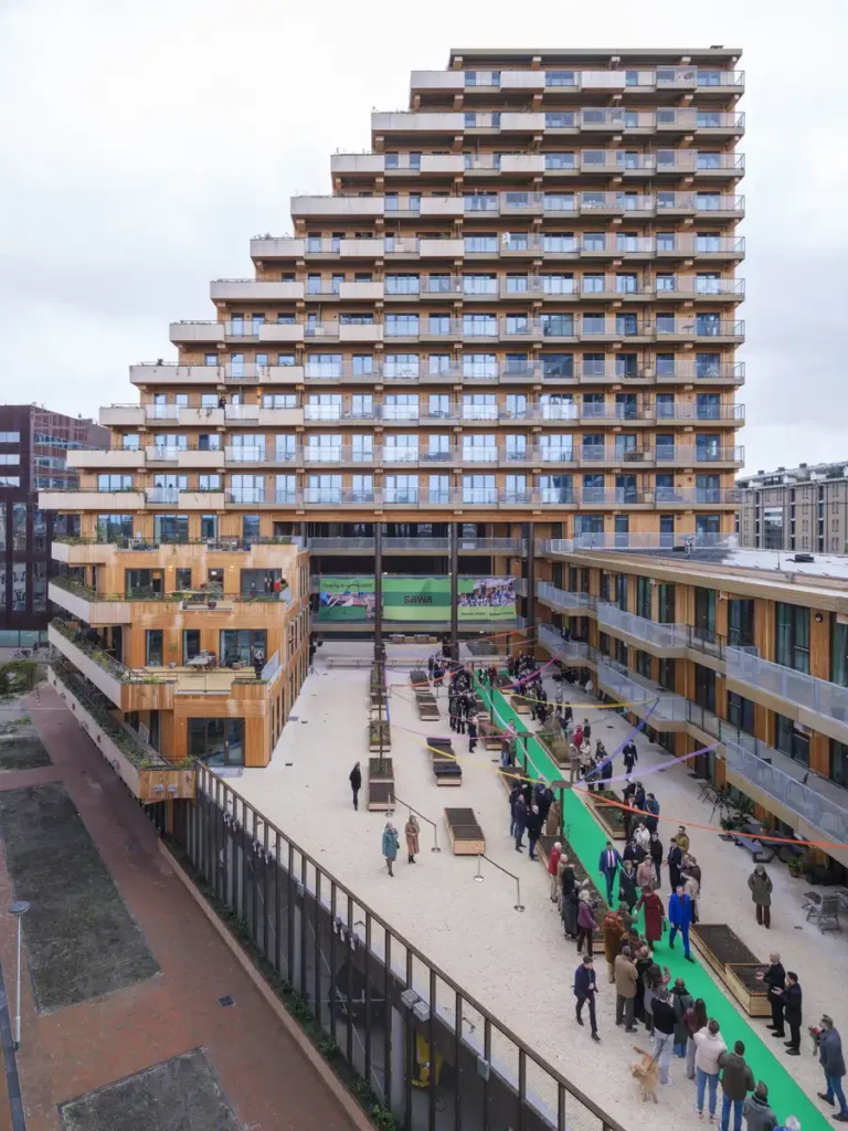 الساحة الداخلية المفتوحة للمبنى، محاطة بالتراسات الخشبية ومسارات الزوار الخضراء المخصصة للتفاعل المجتمعي.