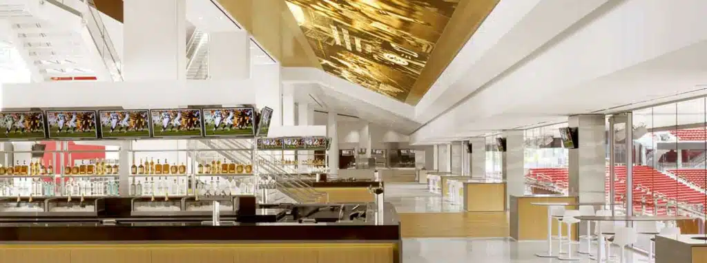 منطقة بار فاخرة داخل ملعب ليفي، مع سقف ذهبي متألق، شاشات عرض متعددة، وأرفف مشروبات مرتبة بإتقان.