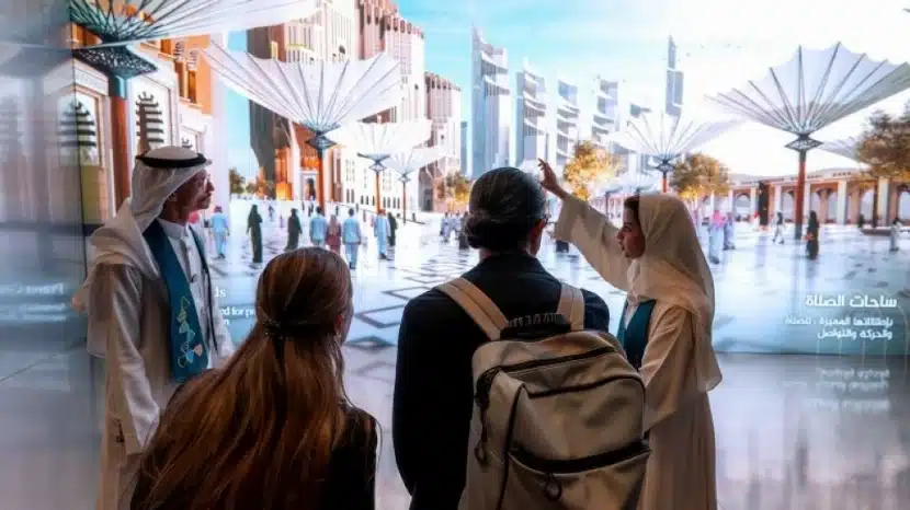  Visitors engage in an interactive experience, one pointing toward the glowing scene and open spaces.