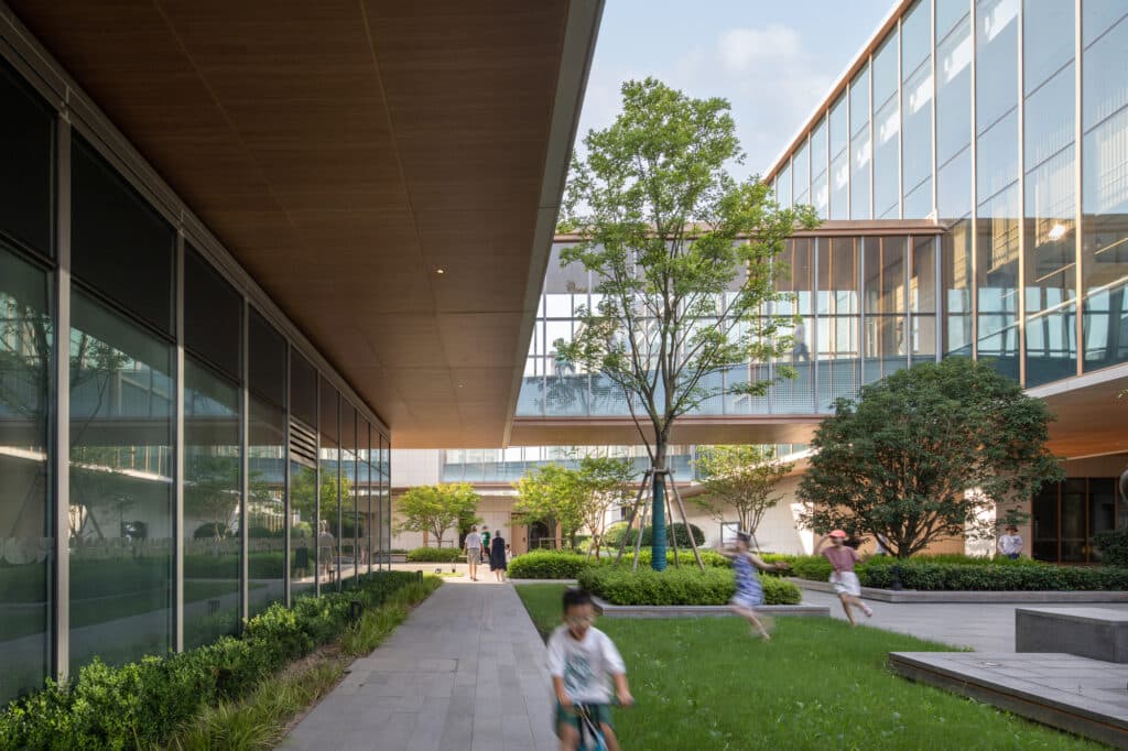 Building facades in warm tones and natural materials, featuring open spaces and central courtyards