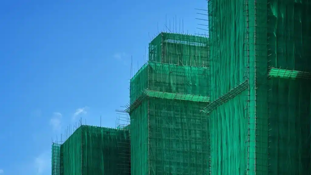Aerial view of towers with bamboo scaffolding and green nets