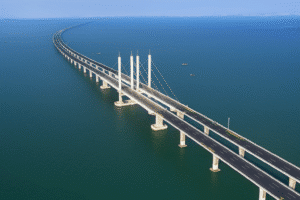 Jiaozhou Bay Bridge Engineering – Aerial image showing the long span of the continuous concrete box girder system over the water, with the cable-stayed section in the middle.