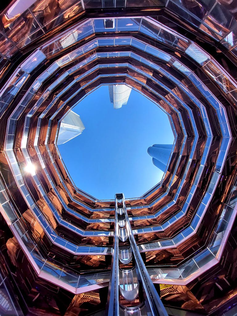 A captivating upward view of a modern architectural landmark in an urban setting, showcasing its unique design.