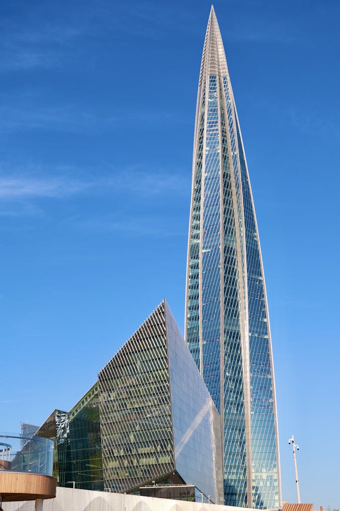 A striking modern skyscraper with sleek glass design reaching into a clear blue sky.