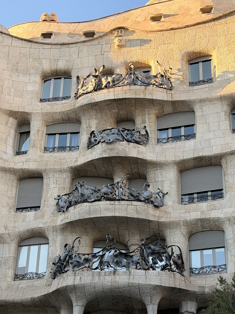 Architectural detail of Casa Mil&agrave; in Barcelona, showcasing its unique stone facade and artistic balconies.