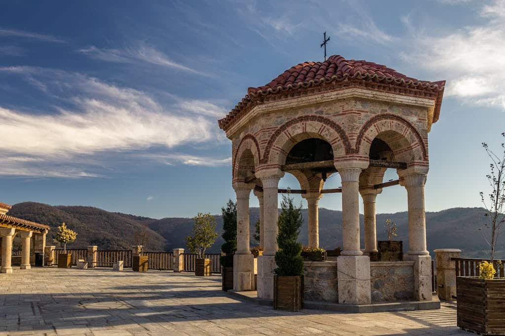 Beautiful temple architecture in Kalabaka, Greece, with mountains in the background, showcasing historic design.