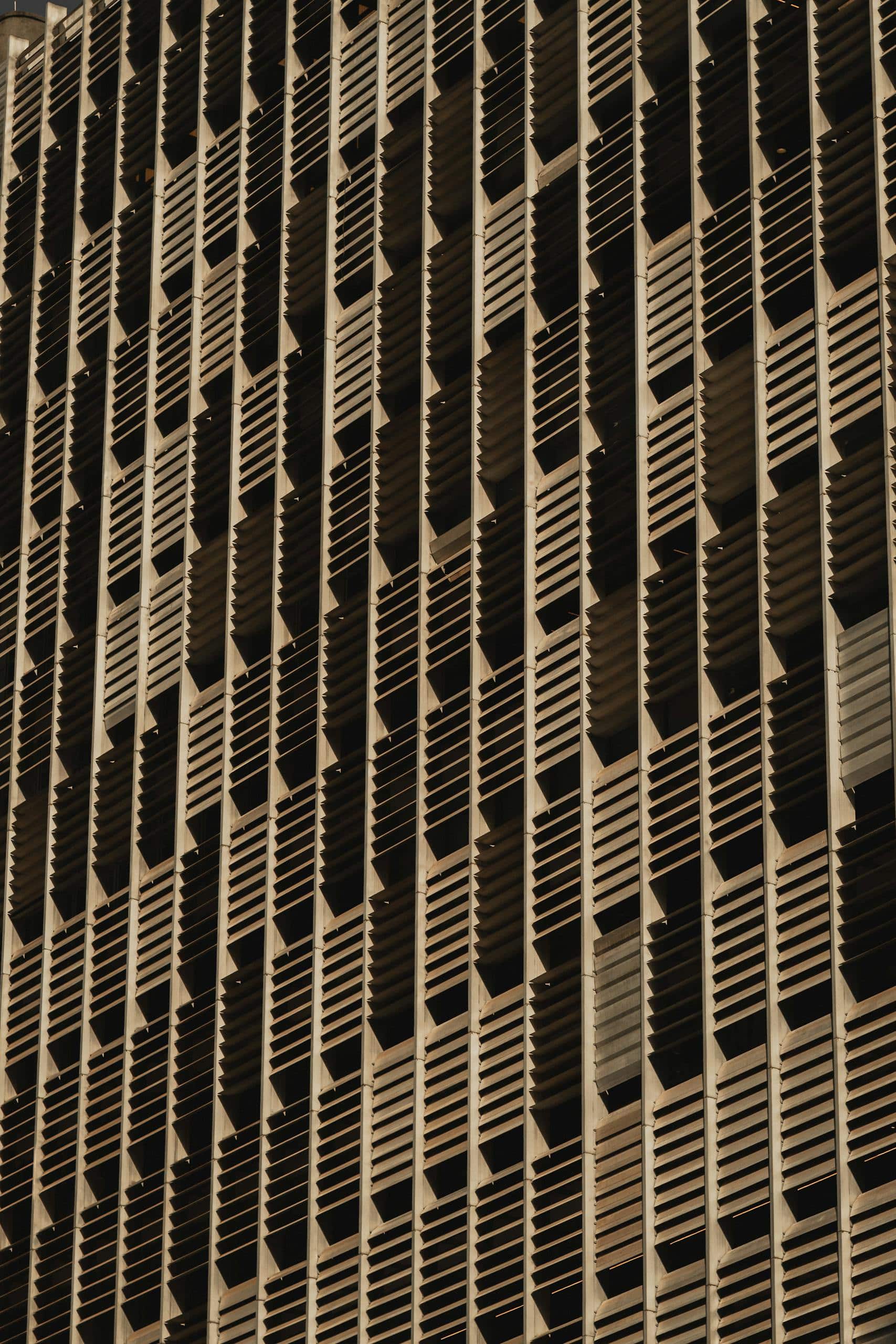 Close-up view of a modern building's facade featuring an intricate jalousie design for shadow play and aesthetics.