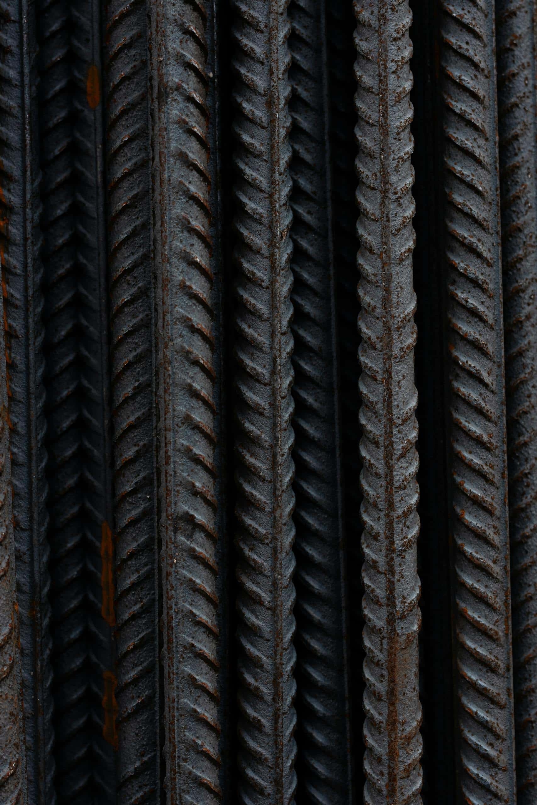 Detailed shot capturing the texture and rust of vertical steel bars in a bundle.