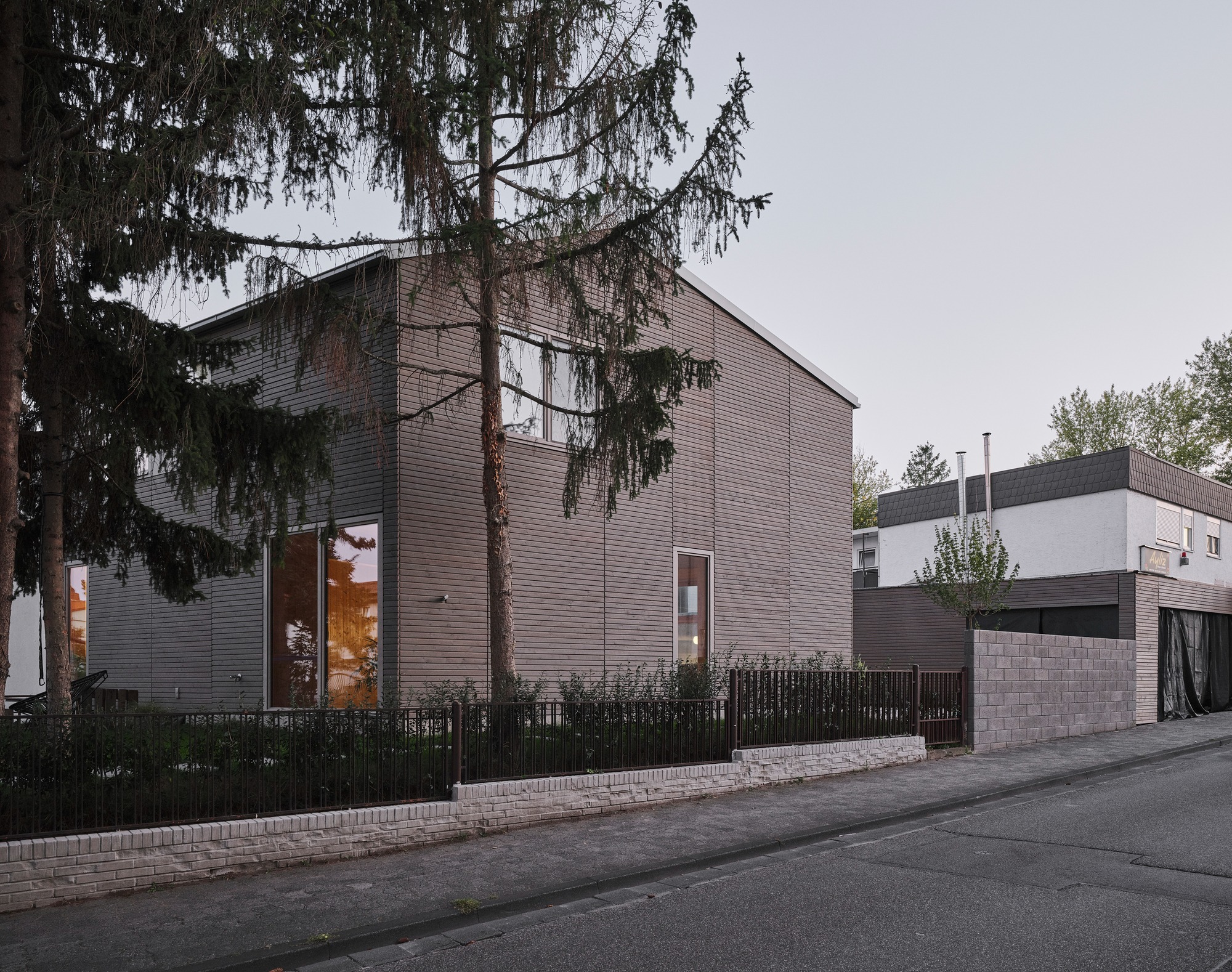 Facade of a sustainable wooden house in Mainz, showing coordinated wooden cladding with staggered windows