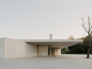 Exterior architectural view of the pavilion showing the floating concrete roof and surrounding landscape.