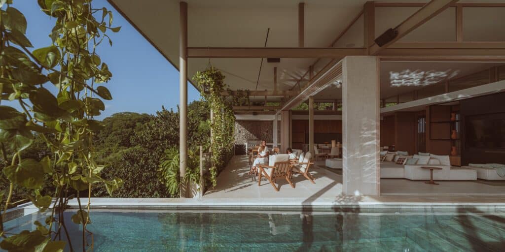 Comprehensive view of Nuri Villa showcasing modern architectural design, seamless integration of indoor and outdoor spaces, green terraces, suspended pool, natural materials, cultural interior details, panoramic ocean views, sustainable construction, and immersive living experience connecting nature, architecture, and local culture.