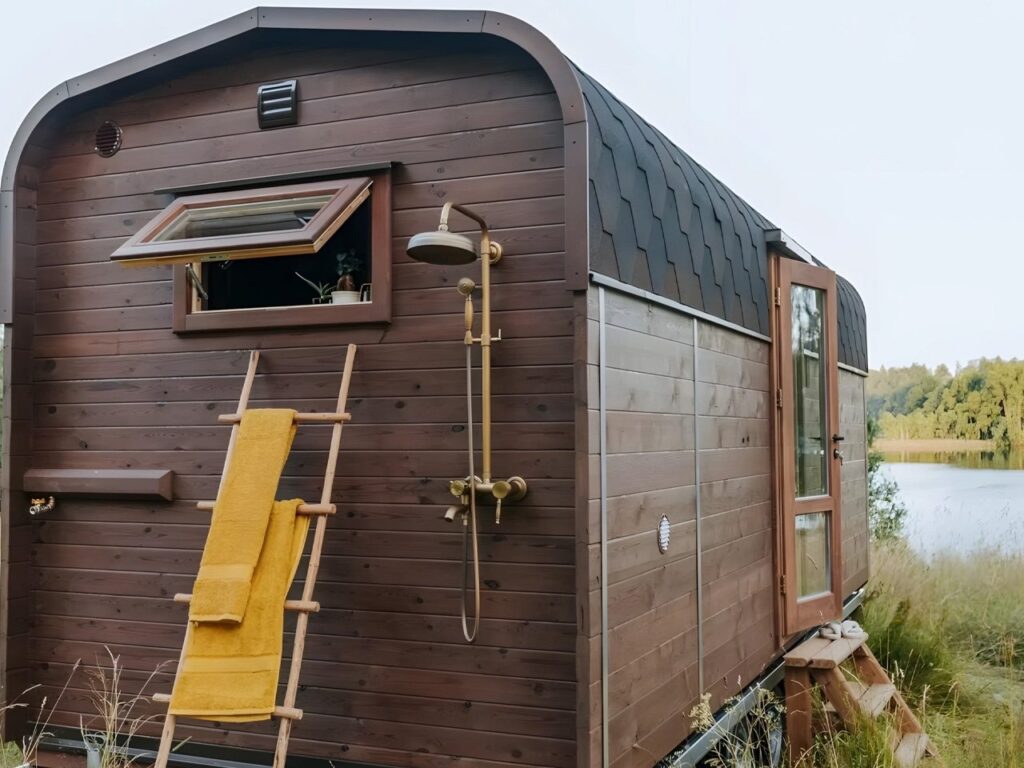 Nature Pod exterior view on a dual-axle trailer showing compact architectural design and mobility features for small-scale living.