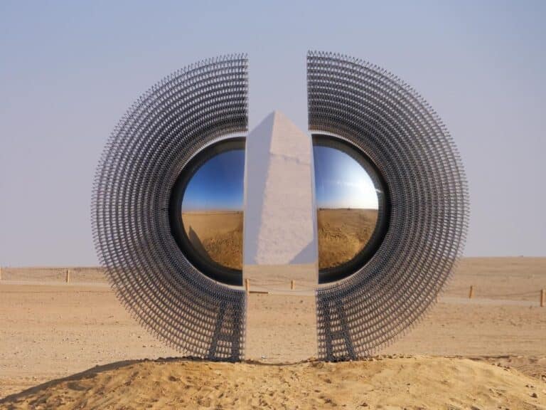 The Shen contemporary art installation on Giza Plateau, a circular aluminum sculpture interacting with sunlight and the Great Pyramids, blending history and modern design.