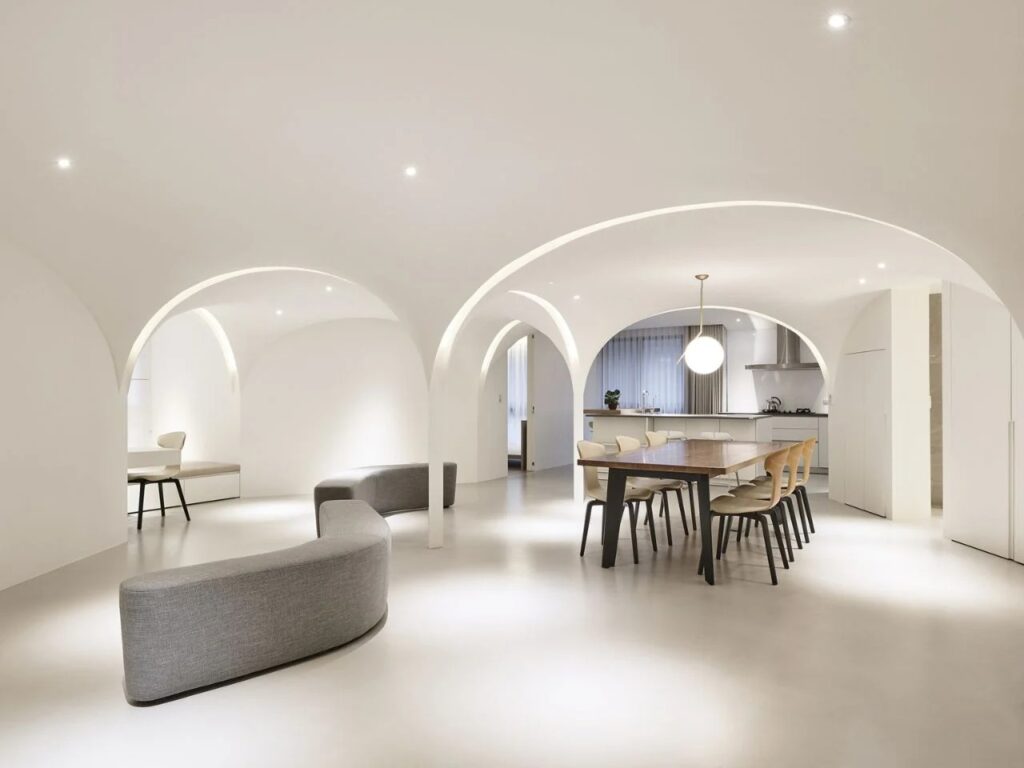 Redesigned urban apartment in Taichung featuring open-plan spaces, pentagonal layout, curved walls, natural light, ventilation, and acoustic differentiation.