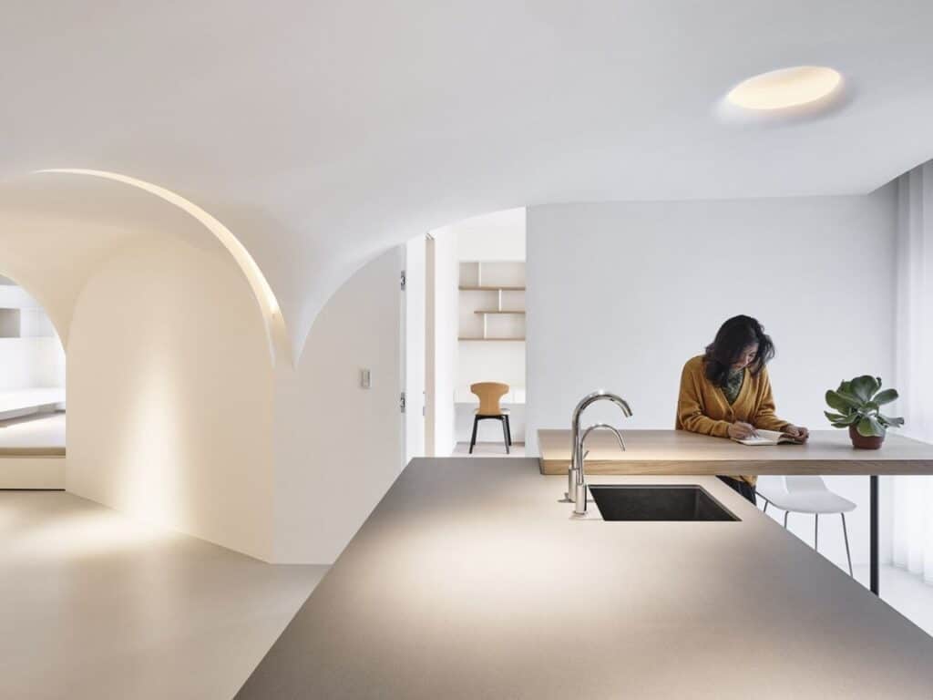 Redesigned urban apartment in Taichung featuring open-plan spaces, pentagonal layout, curved walls, natural light, ventilation, and acoustic differentiation.