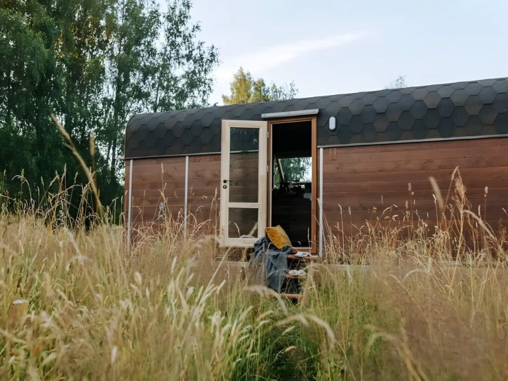 Nature Pod exterior view on a dual-axle trailer showing compact architectural design and mobility features for small-scale living.