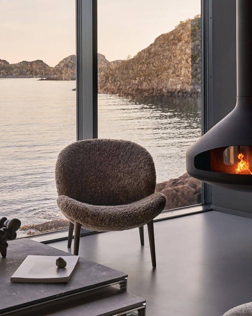 Exterior view of Vipp guesthouse on Storomula island showing wooden stilts and rocky coastline