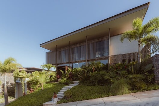 Comprehensive view of Nuri Villa showcasing modern architectural design, seamless integration of indoor and outdoor spaces, green terraces, suspended pool, natural materials, cultural interior details, panoramic ocean views, sustainable construction, and immersive living experience connecting nature, architecture, and local culture.