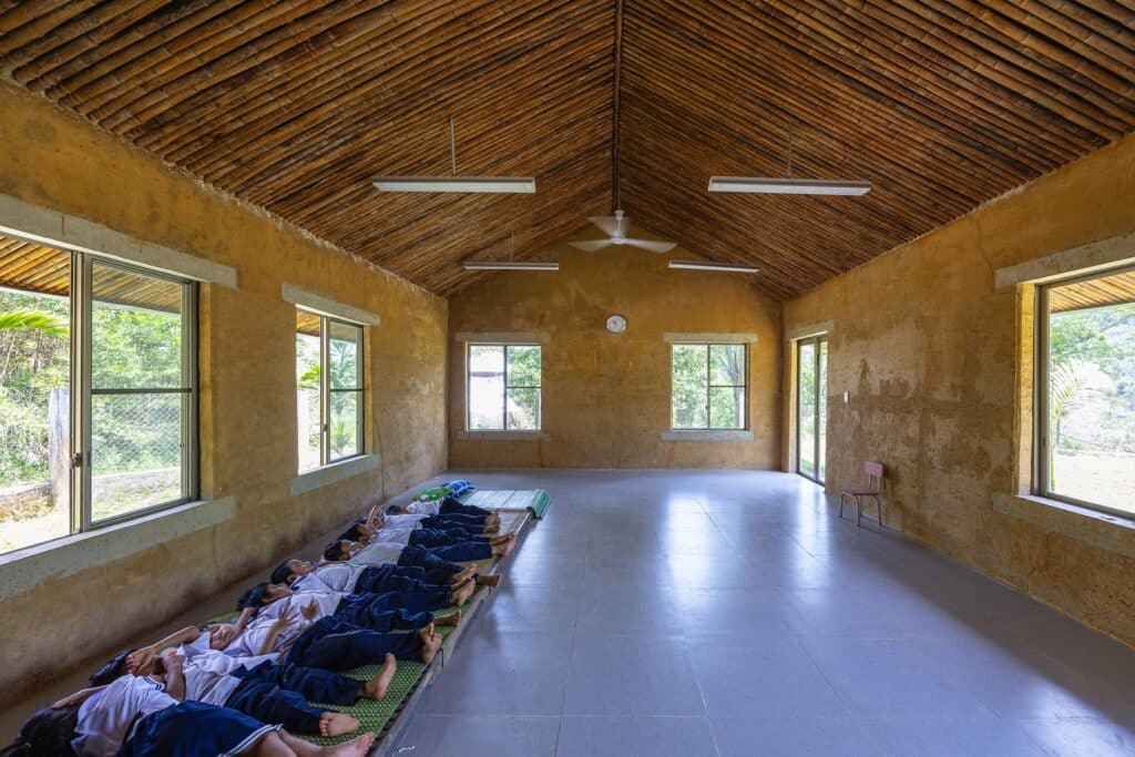 Nuoc Ui School classrooms constructed with rammed earth walls and bamboo roofs reflecting local material use.