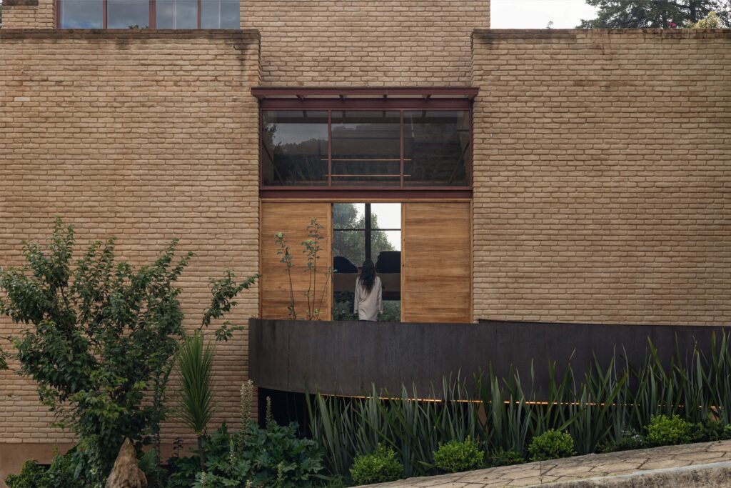 Casa La Sierra, an architectural project in the Huayutipac forest, exemplifies sustainable design by integrating the building with natural slopes, local materials, split-level interiors, and suspended transitional spaces, creating a dialogue between architecture and nature.