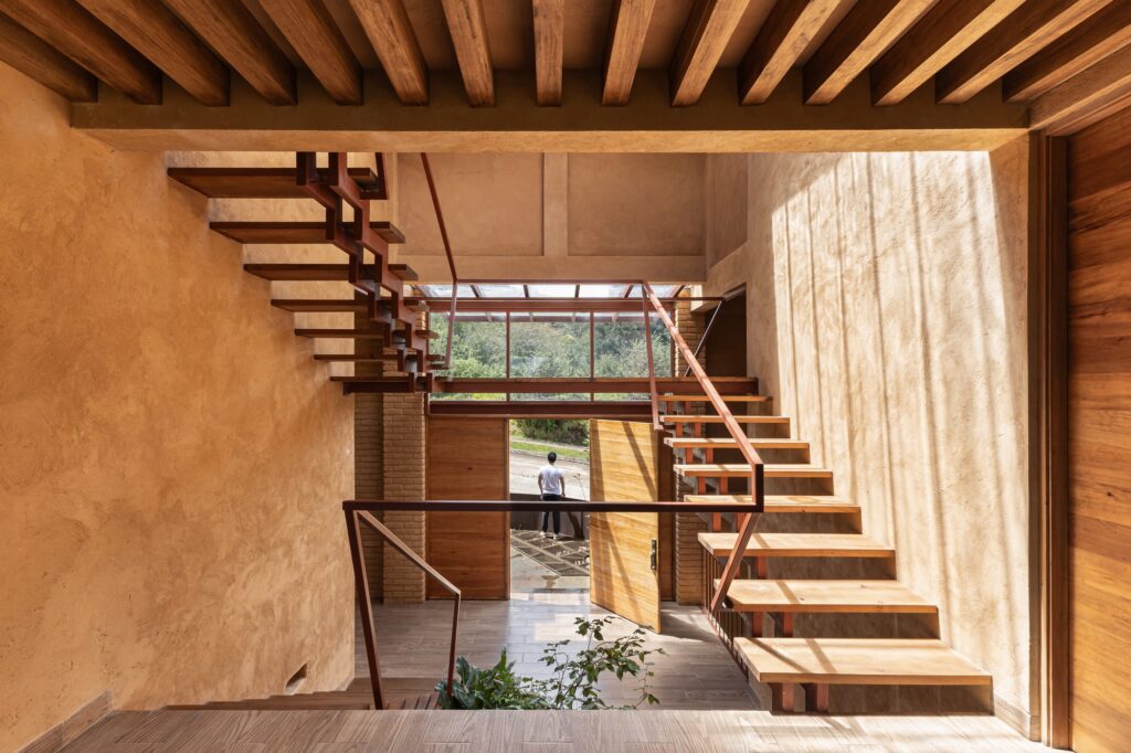 Casa La Sierra, an architectural project in the Huayutipac forest, exemplifies sustainable design by integrating the building with natural slopes, local materials, split-level interiors, and suspended transitional spaces, creating a dialogue between architecture and nature.