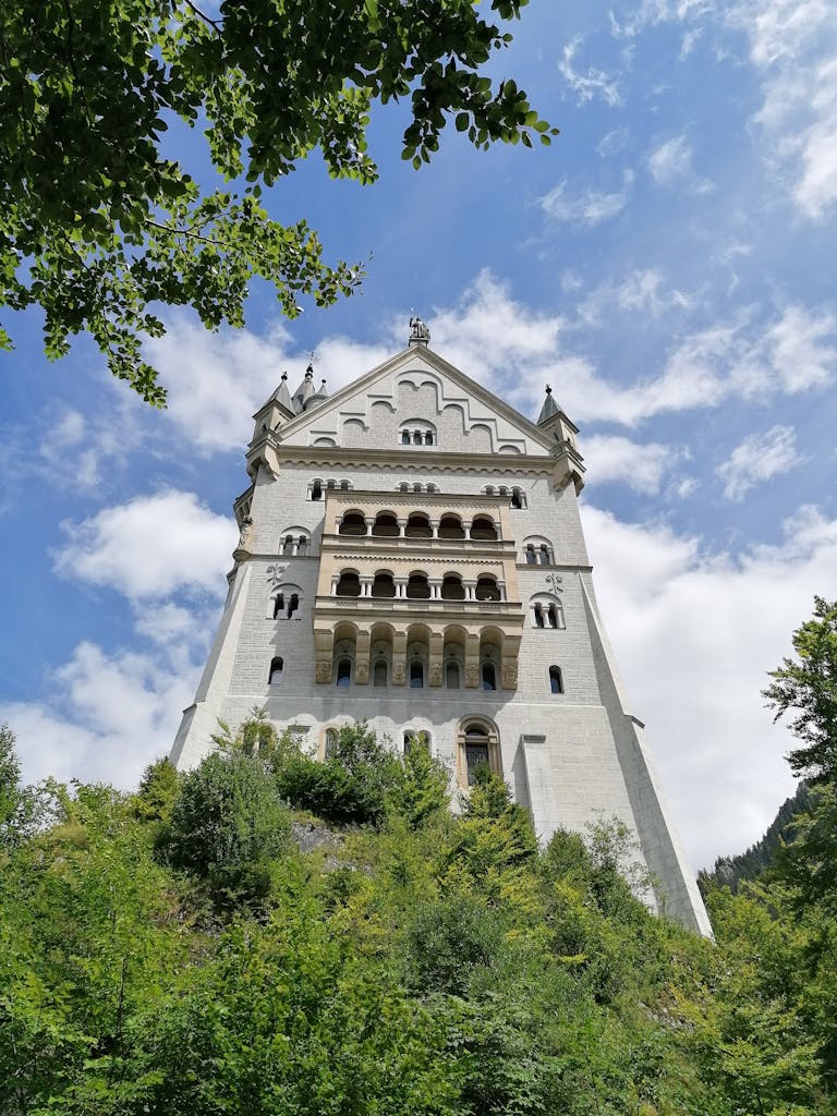Majestic Gothic-style castle tower set against a vibrant blue sky, perfect for travel and architecture lovers.