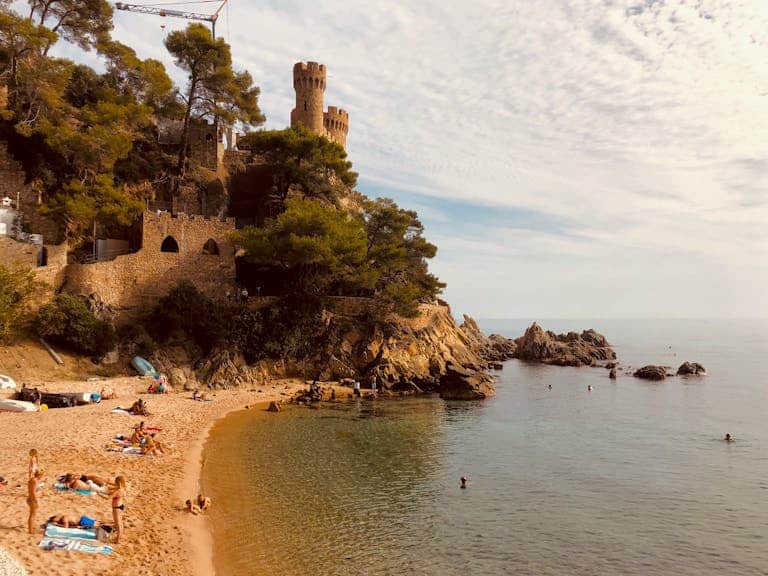 Scenic view of a medieval castle by the beach in Catalonia, Spain.