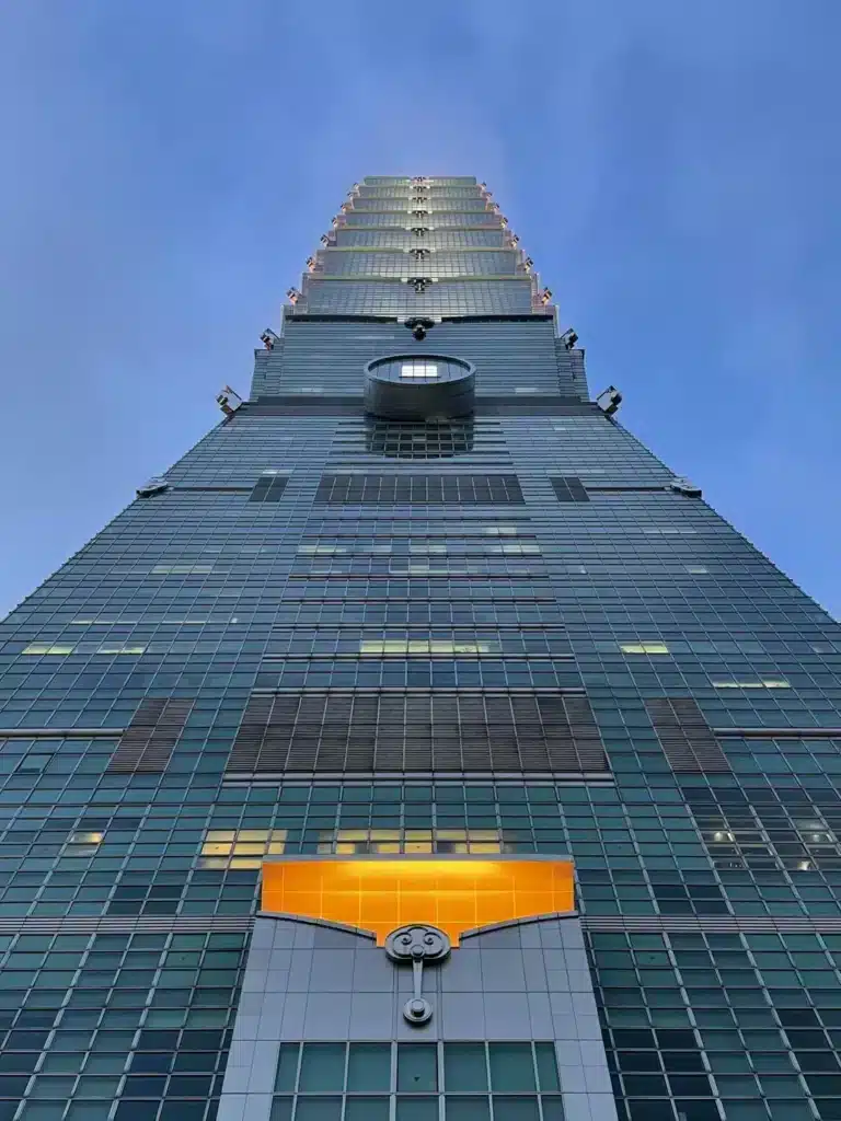 منظر بزاوية منخفضة للغاية لناطحة سحاب تايبيه 101، يبرز الواجهة المكدسة والمقسمة والعنصر الدائري المزخرف