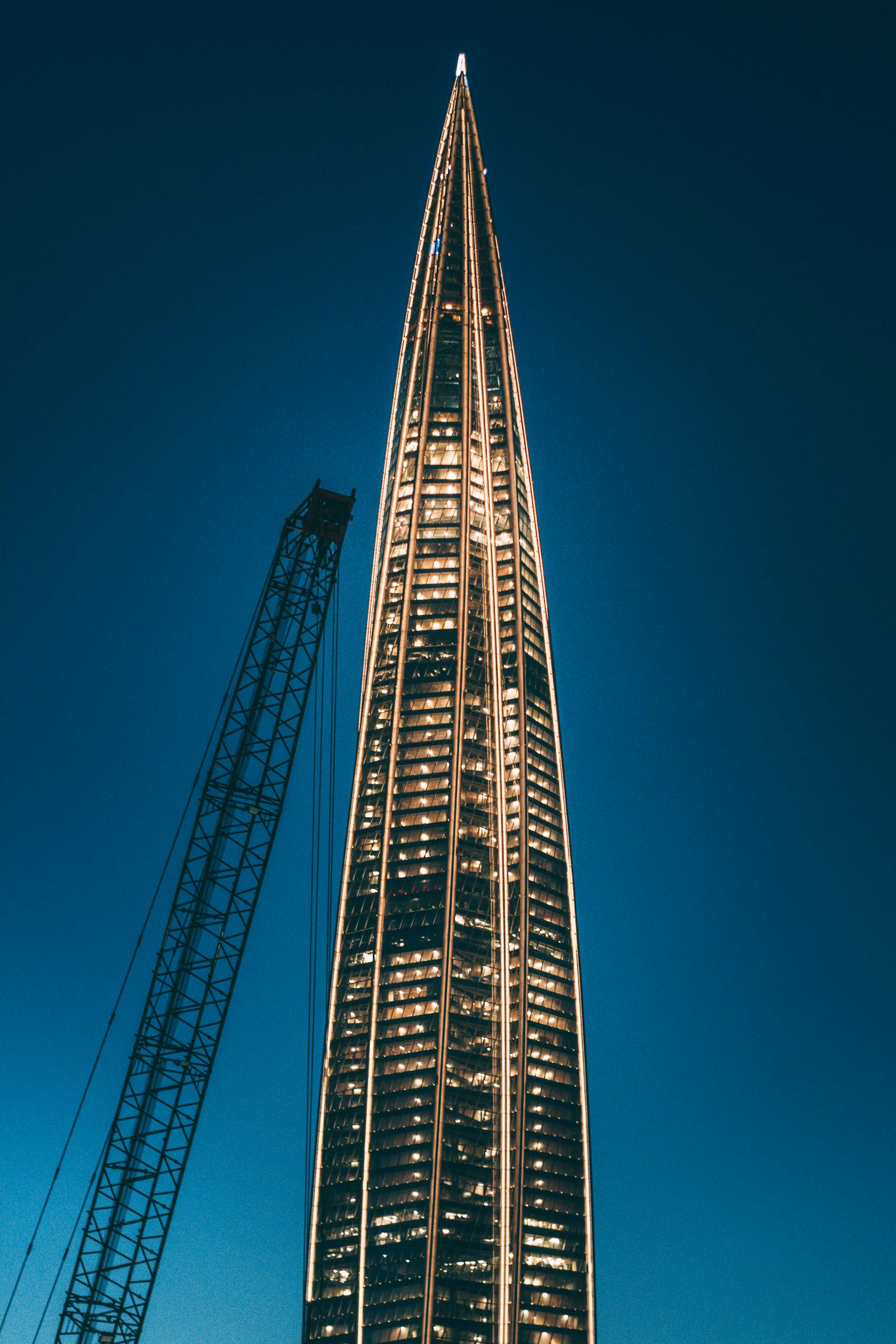Stunning view of the illuminated Lakhta Center tower and crane at twilight in St. Petersburg, Russia.