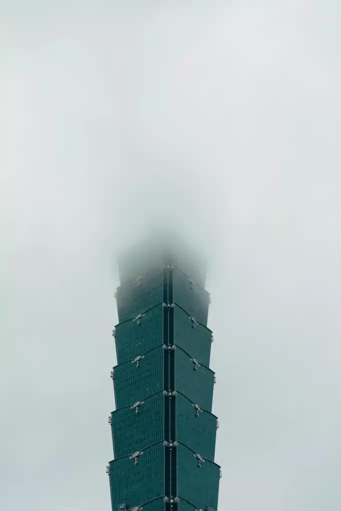 واجهة ناطحة سحاب تايبيه 101 المقسمة تمتد صعوداً، محجوبة جزئياً بسحب منخفضة أو ضباب كثيف.