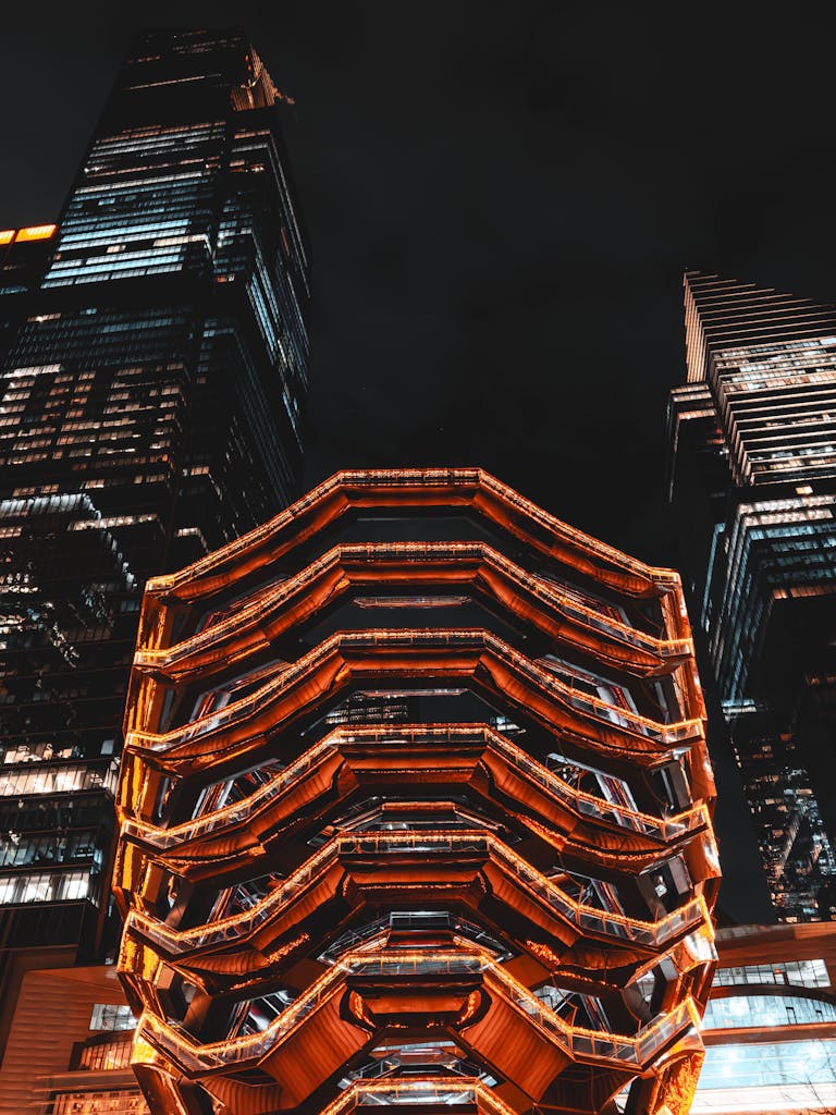 The Vessel in New York City glowing against the night sky, showcasing modern architecture.