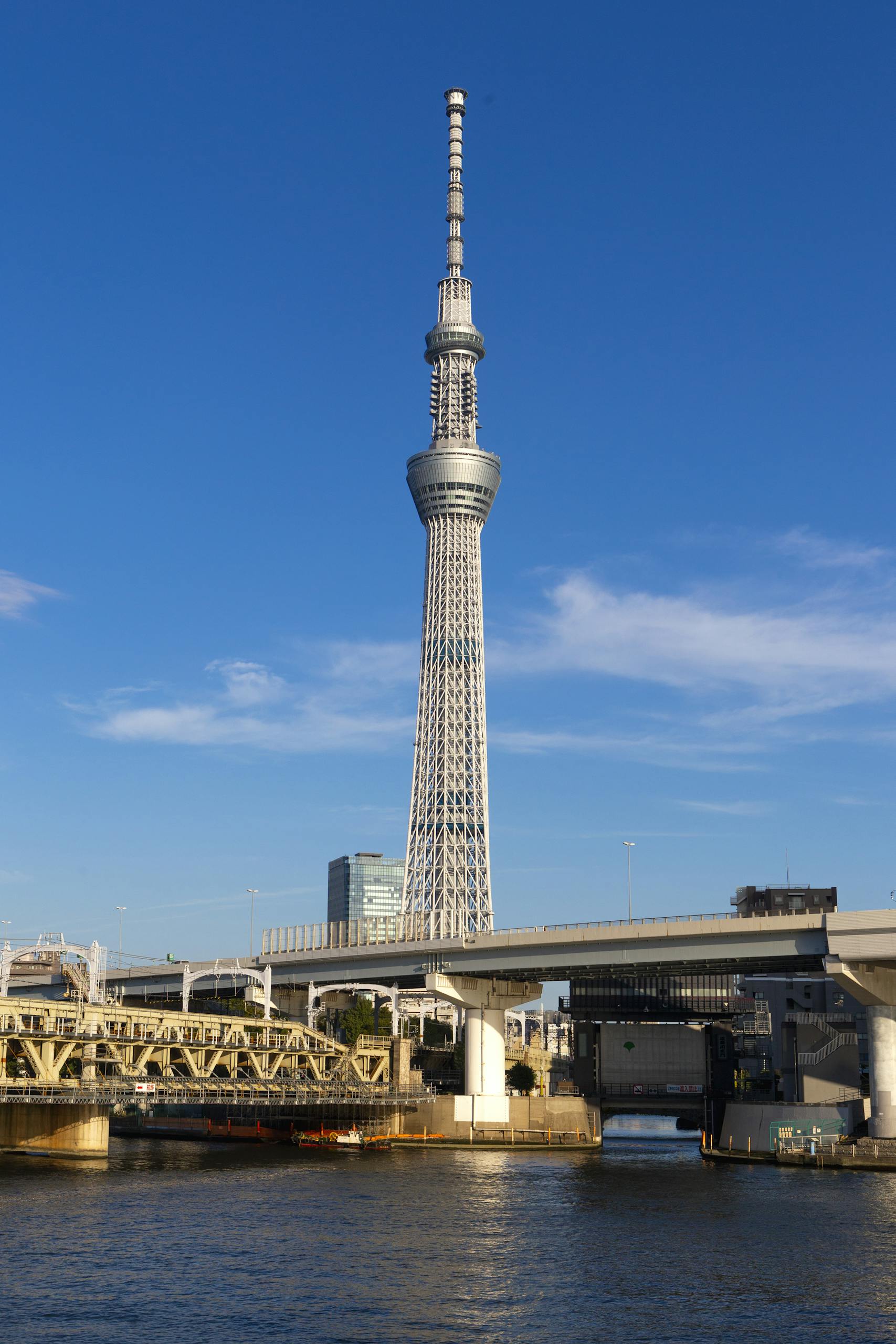Tokyo Skytree stands tall over the Sumida River in a vibrant urban setting.