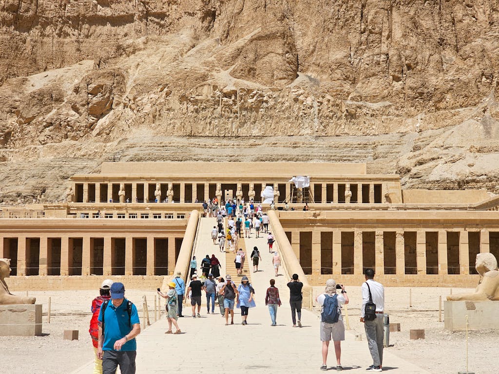 Visitors exploring Hatshepsut Temple in Luxor, Egypt, showcasing ancient architecture.
