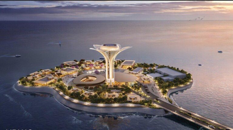 Aerial rendering of Ajdan Island in Khobar at dusk, showcasing a central illuminated tower with petal-like canopy, surrounding low-rise buildings, waterfront promenade, and connecting bridge over the Arabian Gulf.