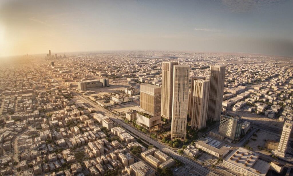 منظر جوي واسع يظهر مجموعة أبراج ذات كساء حجري تندمج مع النسيج العمراني الكثيف المحيط.