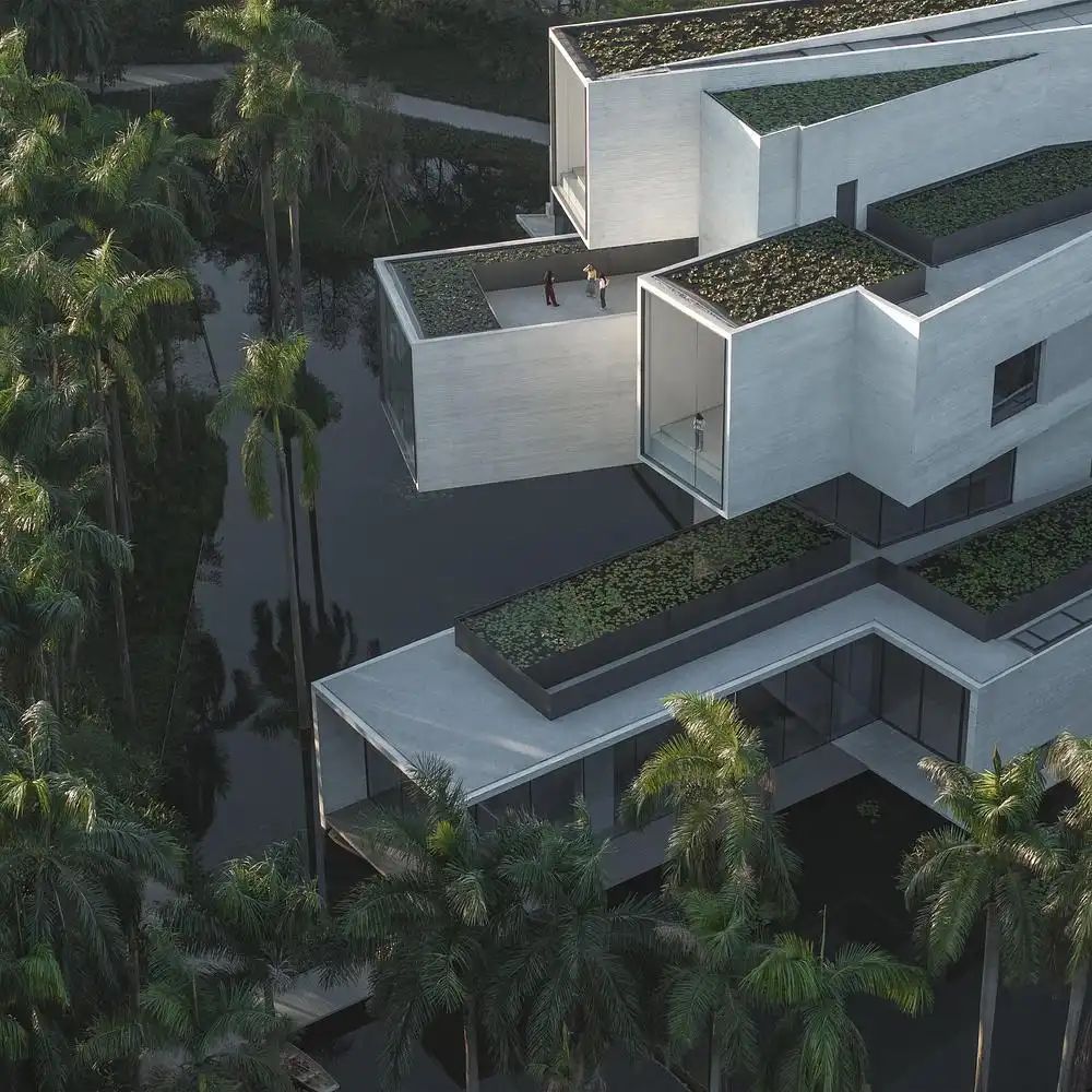 Stacked concrete terraces floating over water with green roofs, reflecting visitors' tranquil interaction with the Wetland Architecture setting.