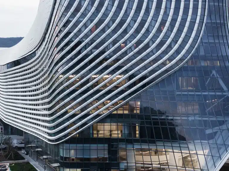 Tower fa&ccedil;ade's glass and white horizontal bands create a fluid, shimmering motion against the sky.