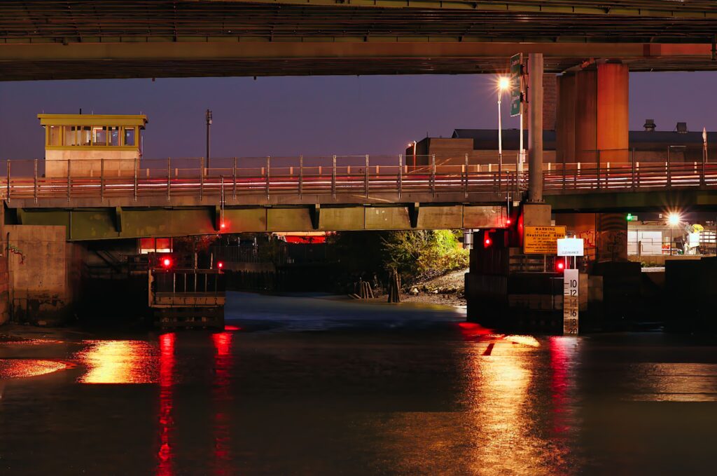 Unionport Bridge in the Bronx at night, showcasing its dual bascule design with pedestrian walkways and bike lanes — part of a $232 million project to upgrade urban infrastructure and marine transportation.