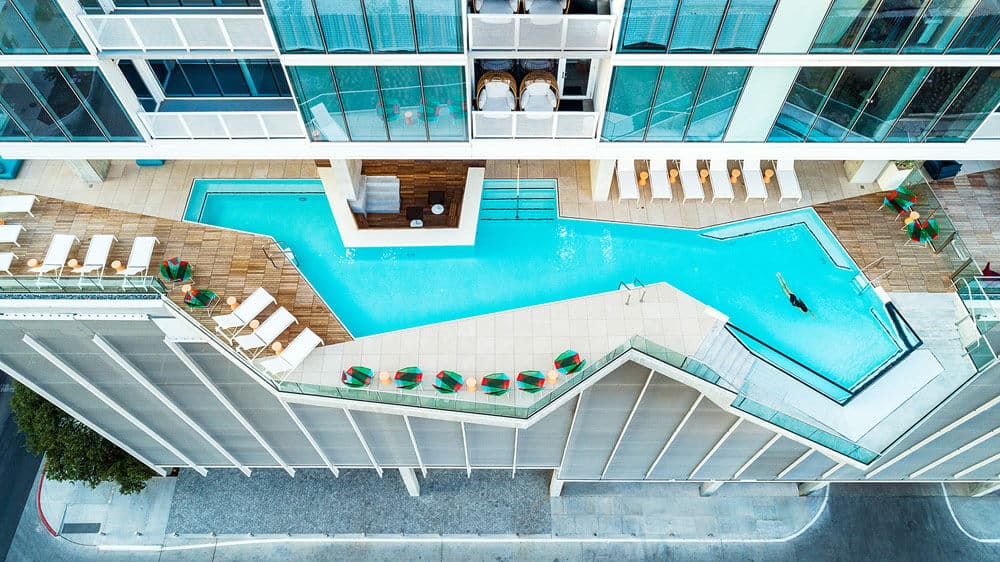 Austin residential tower rooftop pool with geometric design and cantilevered balconies, showcasing modern luxury living in Texas.