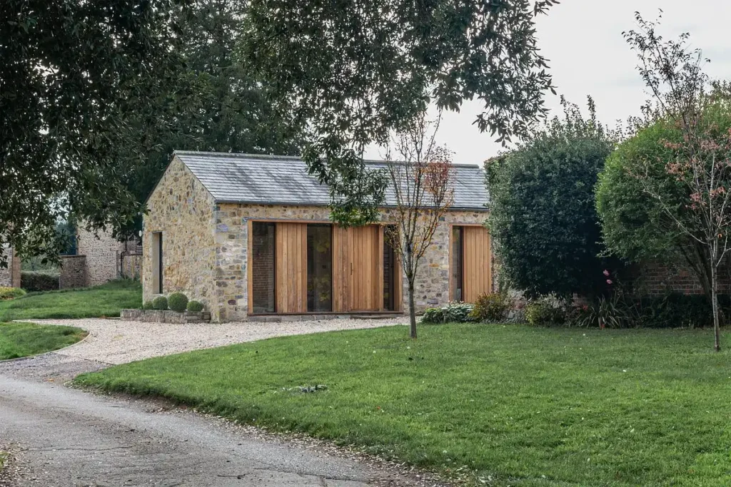 الواجهة الحجرية القديمة متناغمة مع الأبواب الخشبية الجديدة وفتحات النوافذ العميقة.