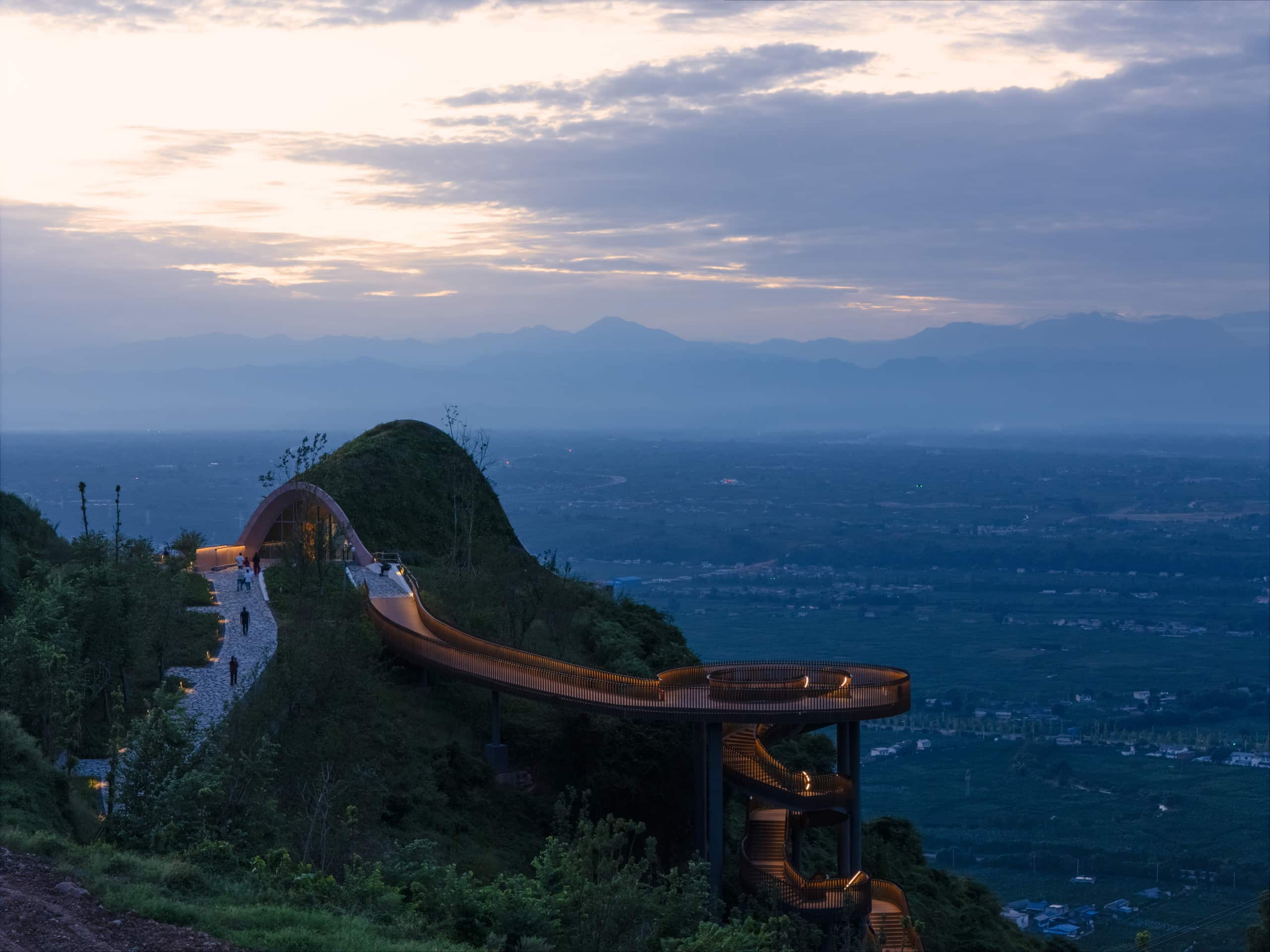 Pujiang Platform in Chengdu, a timber pavilion covered with earth overlooking hills and plains, featuring an illuminated spiral walkway and arched glass facade.