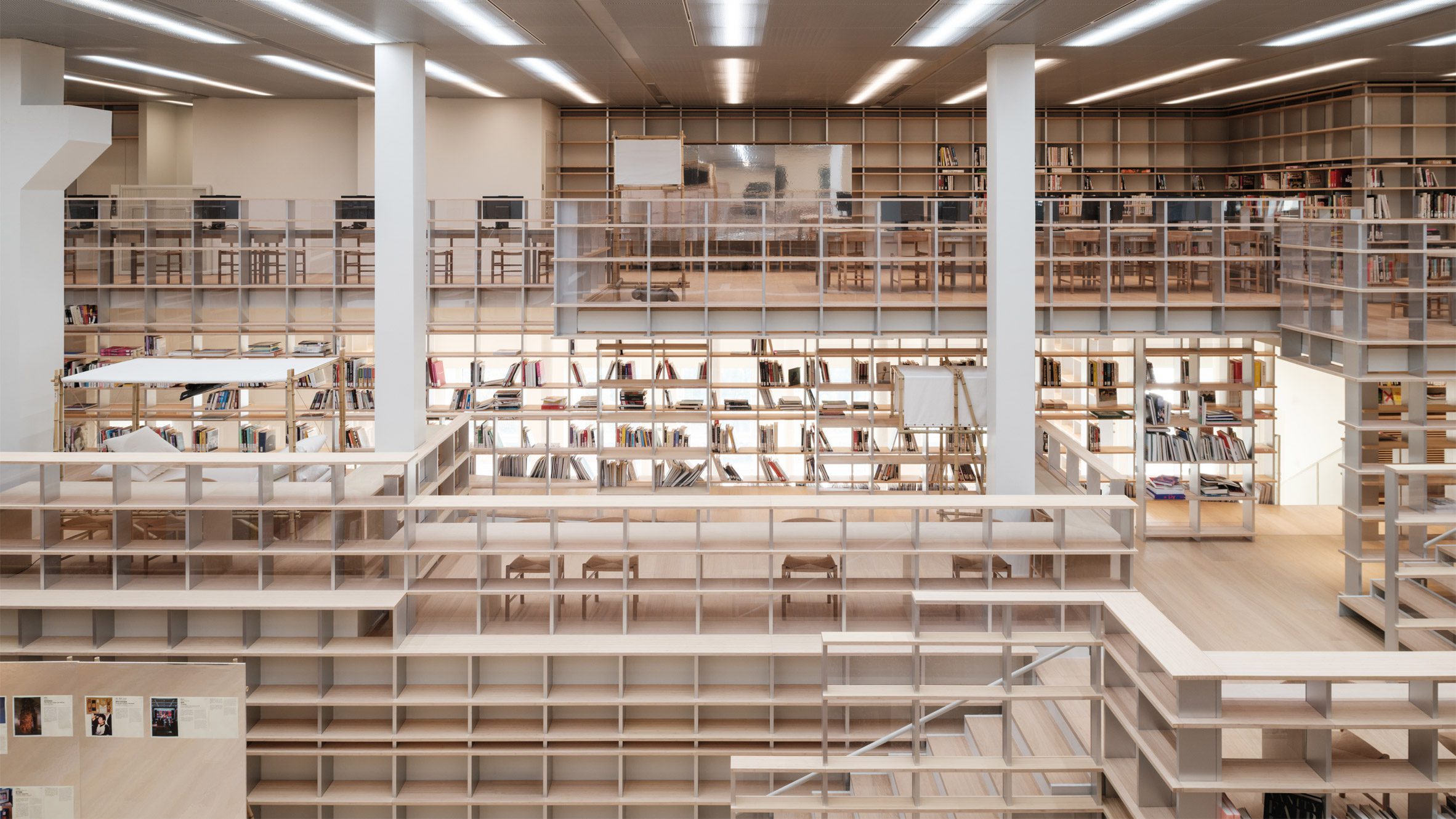 Espace Gabrielle Chanel art library interior with multi-level wooden shelving, open reading areas, and integrated stairways within Shanghai’s Power Station of Art.