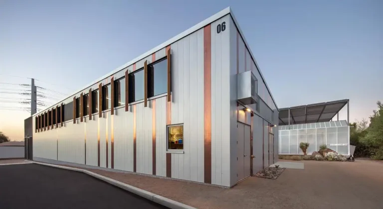 Exterior view of the Ahearn Horticulture Center, a 4500 sq ft functional building at the Hazel Hare Center for Plant Science Phase II in Phoenix, featuring vertical metal cladding and copper accents under evening light.