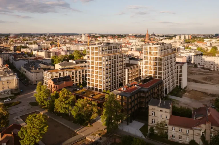 Aerial view of the New Port residential development in Bydgoszcz, Poland, showcasing modern apartment blocks with loggia facades integrated into the historic urban fabric along the Brda River.