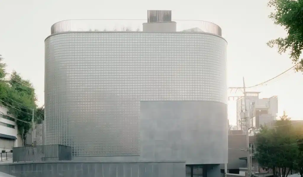 Wooyoungmi Seoul flagship exterior with curved glass block facade and textured concrete base
